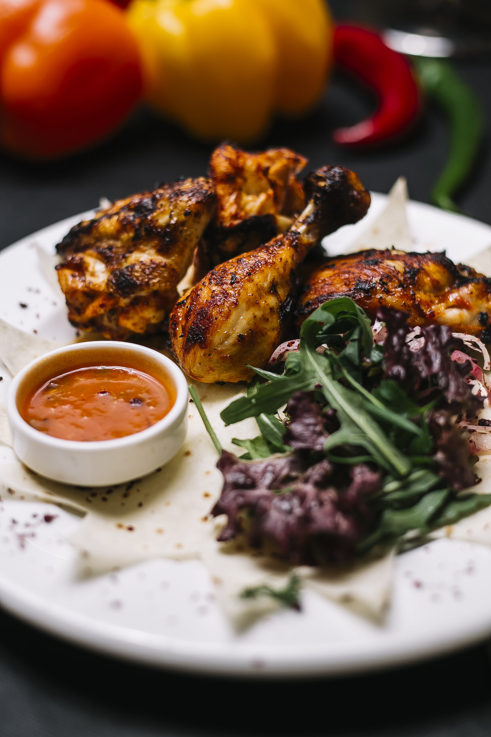 side view of chicken kebab on lavash served with fresh herbs onion and adjika sauce